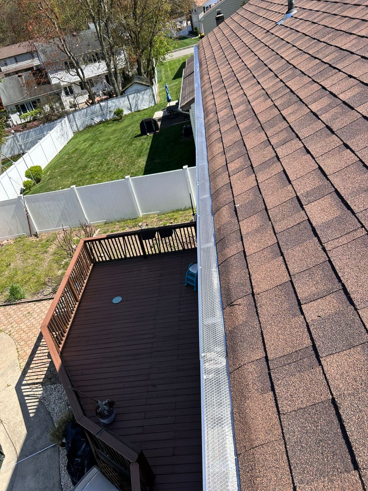An aerial view of a roof with a deck in the background.