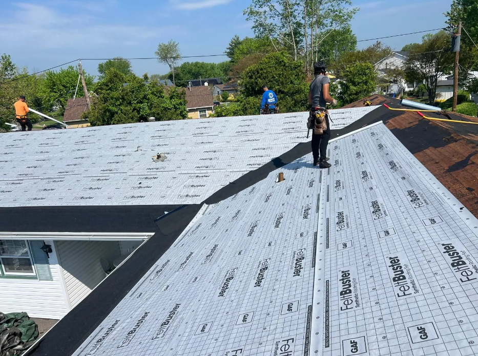 A man is standing on the roof of a house.