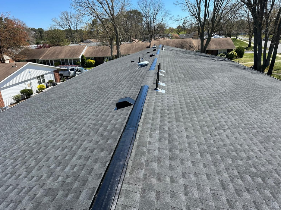 A roof with a lot of shingles and trees in the background.