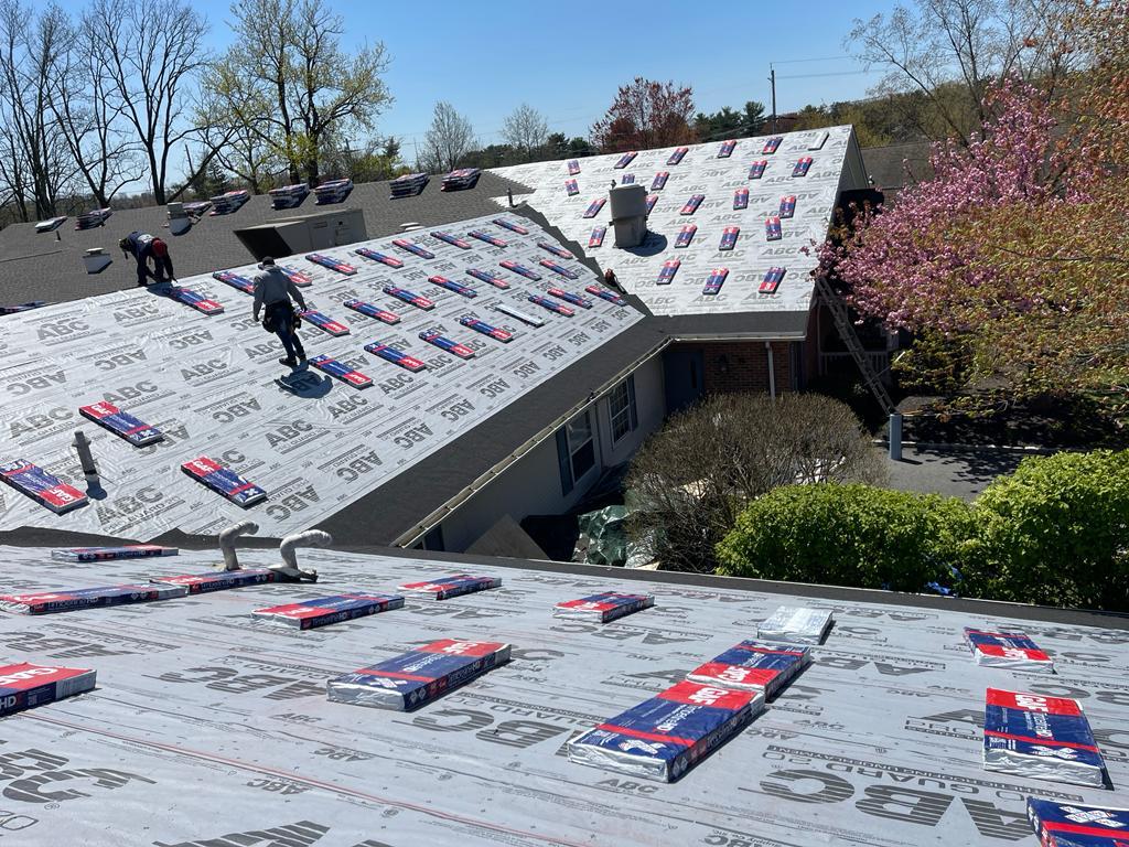 A man is standing on the roof of a house.