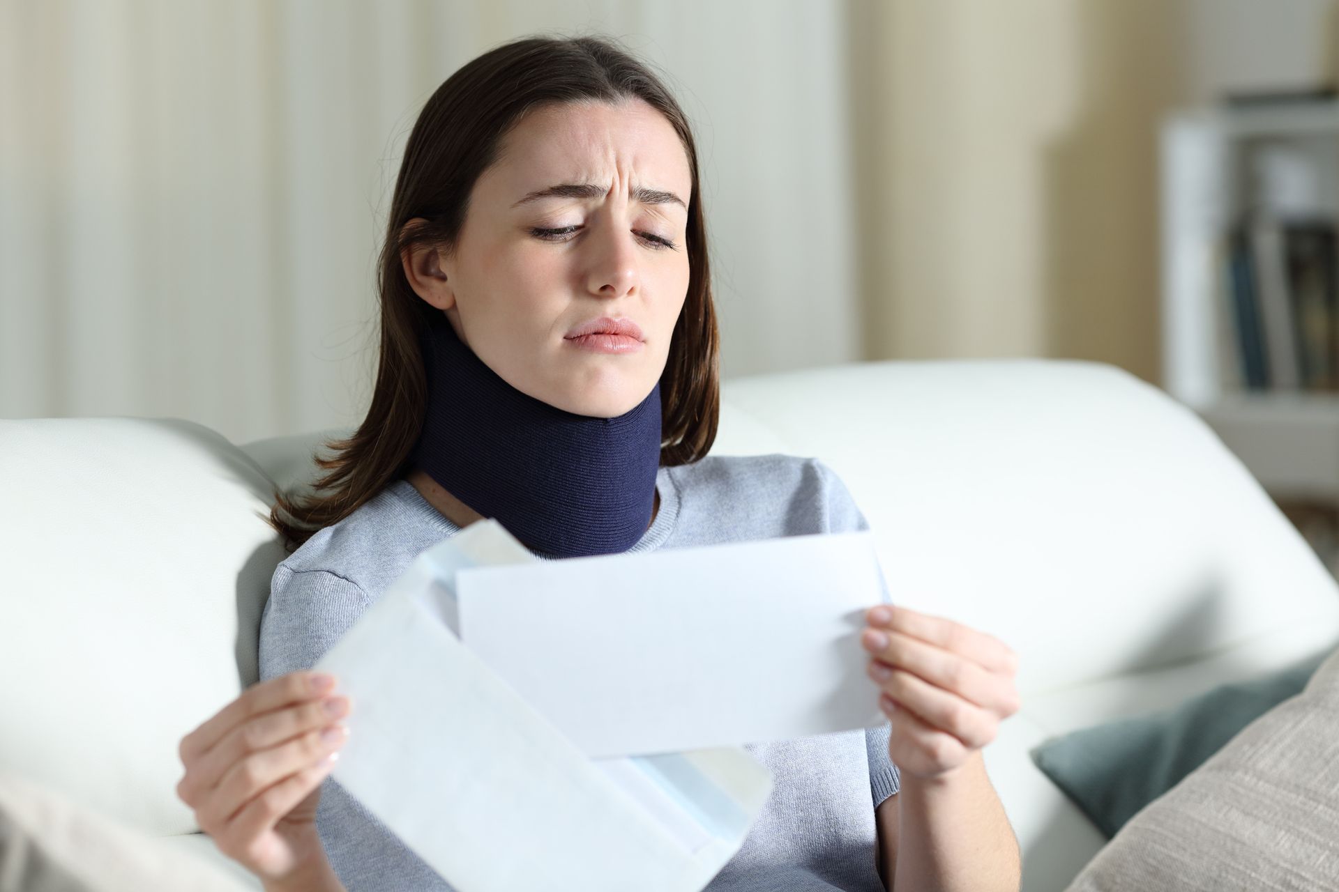 Sad disabled woman reading bad news on a letter about an insurance claim.