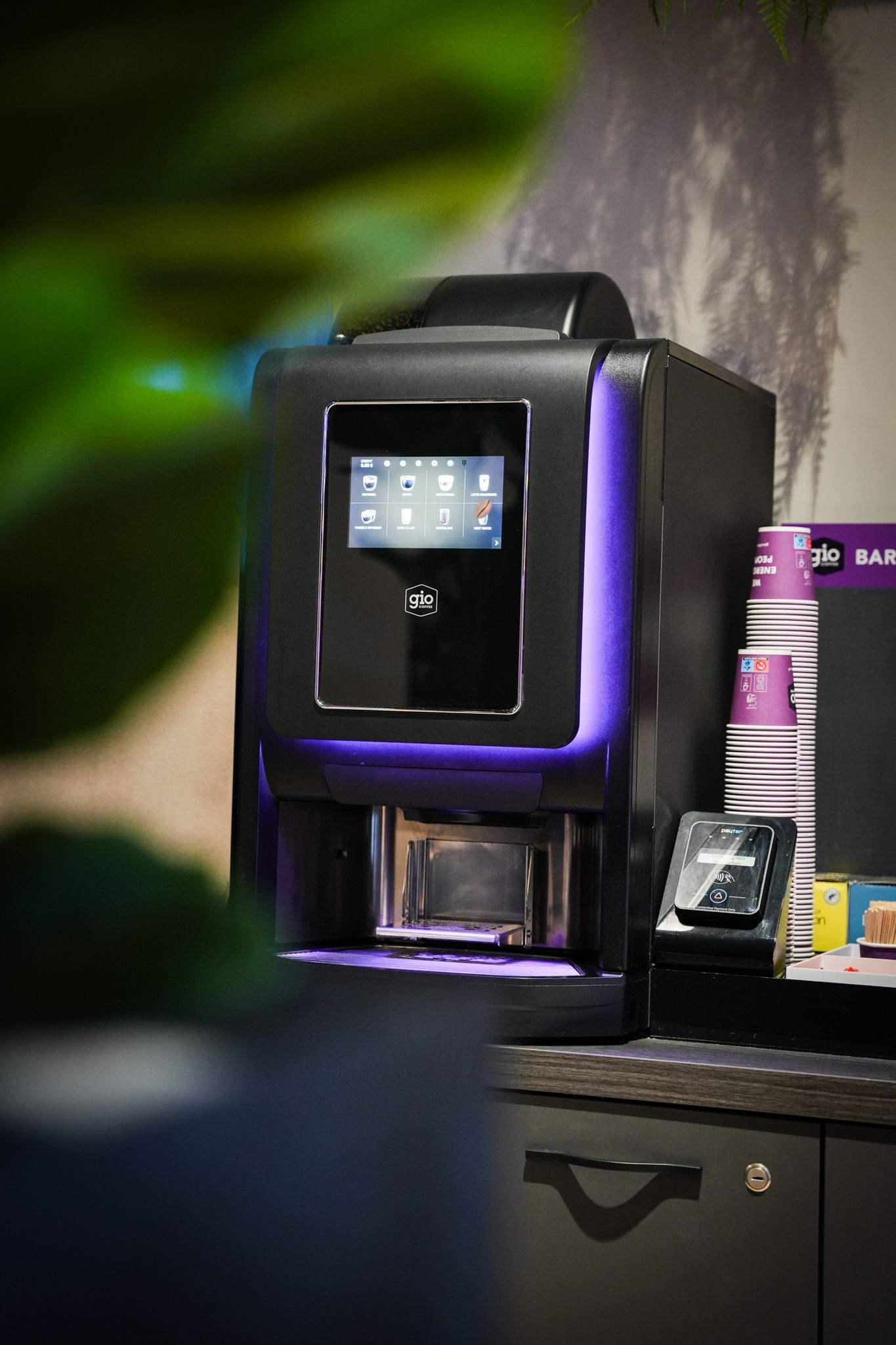 Een close-up van een koffiezetapparaat met een paars licht erachter