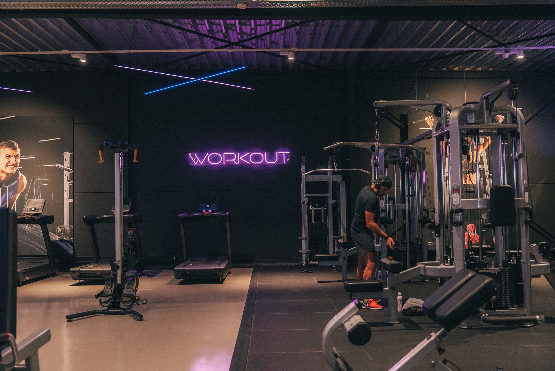Een grote lege sportschool met veel fitnessapparatuur.