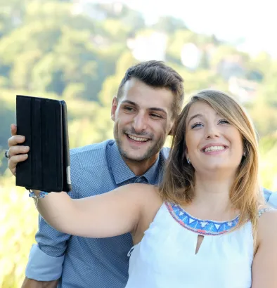 A man and woman are taking a selfie with a tablet