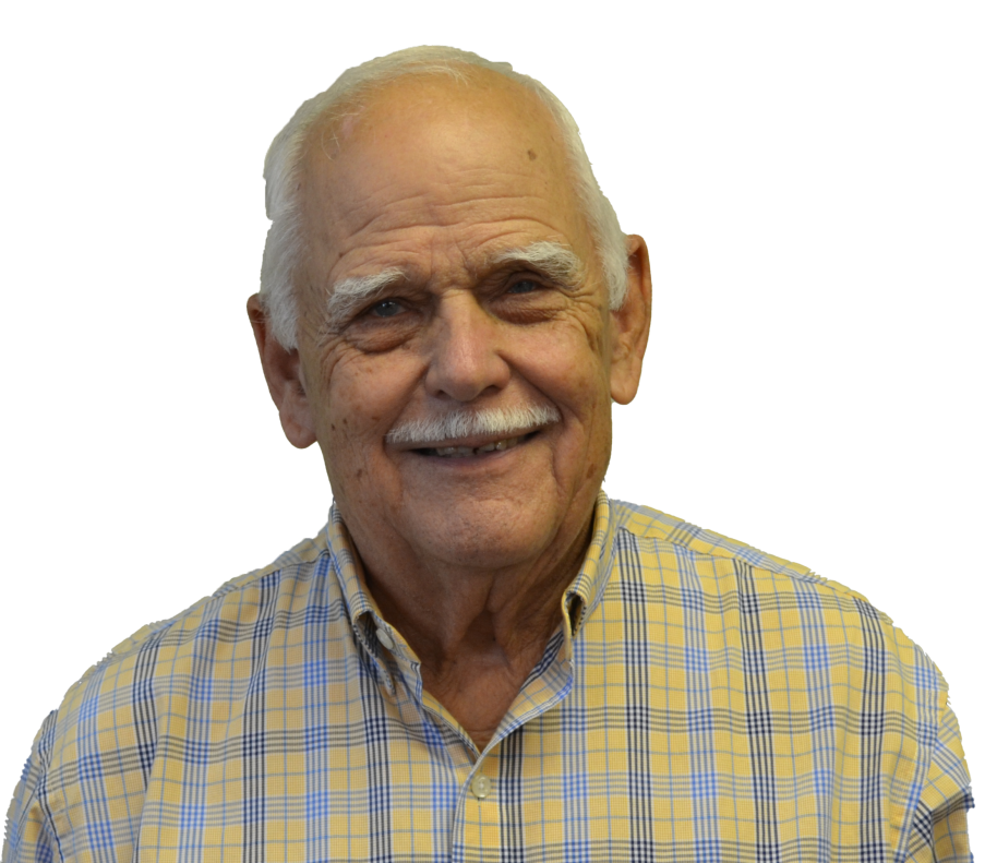 Smiling older man with white hair and mustache, wearing a yellow plaid shirt.