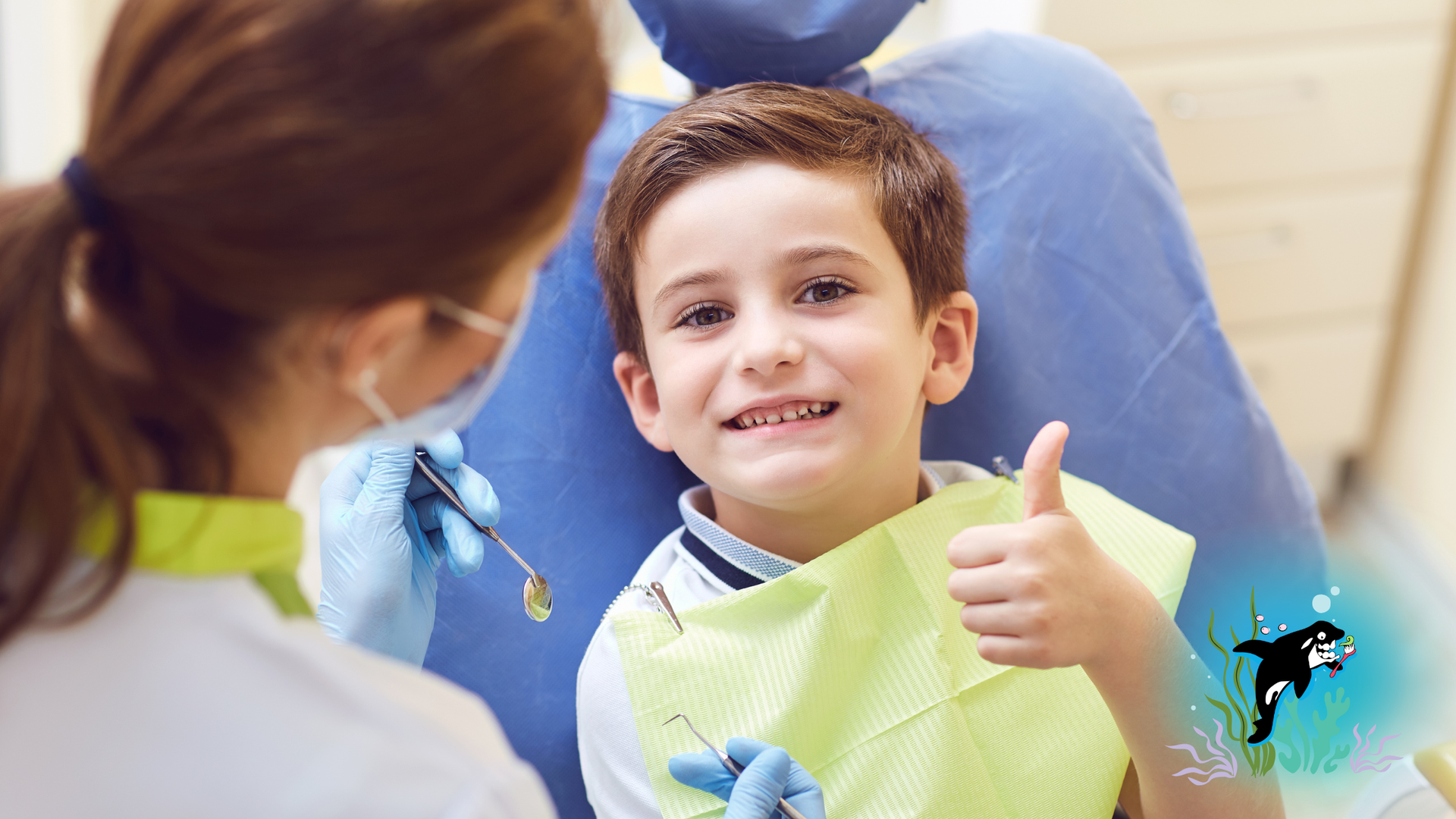 Boy at dentist smiles and gives thumbs up. Dentist in background.