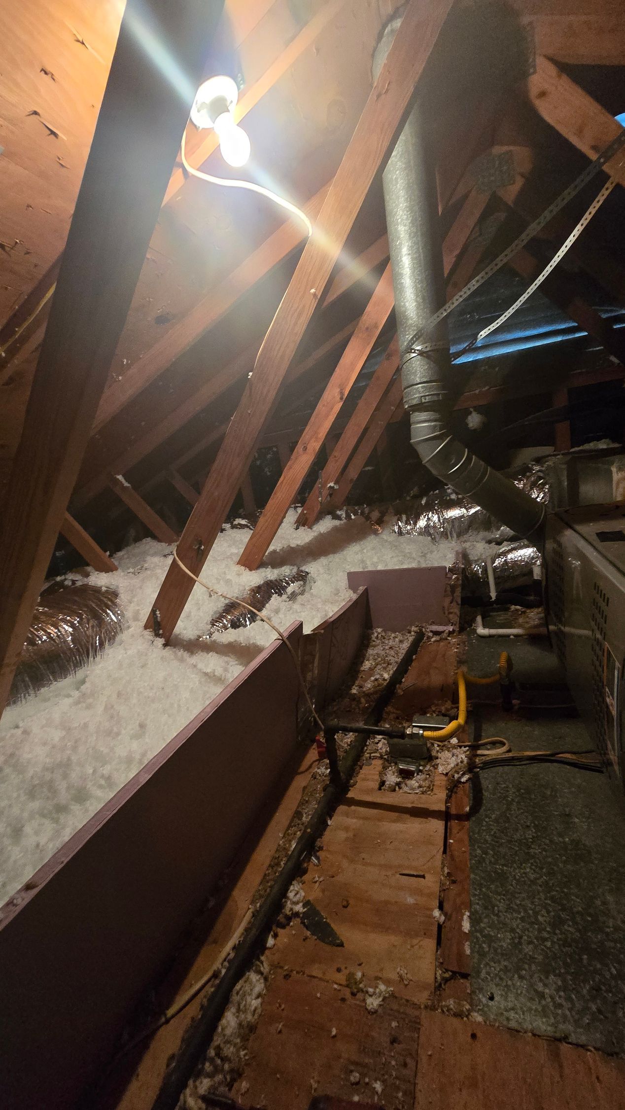 Snowy rooftop with metal beams, a bright light, and a narrow walkway beside industrial equipment.
