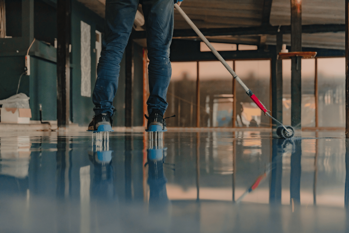 A person on roller skates mopping a glossy floor in a bright indoor space