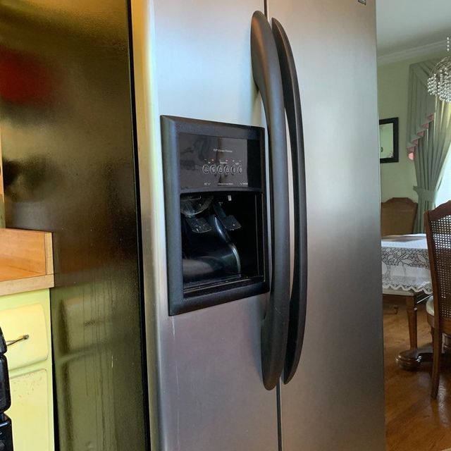 Modern gray kitchen with stainless steel refrigerator and white countertops