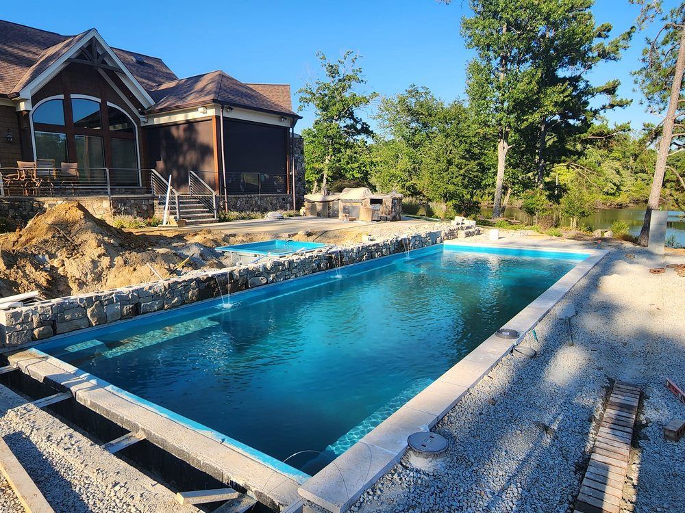 A large swimming pool is being built in front of a house