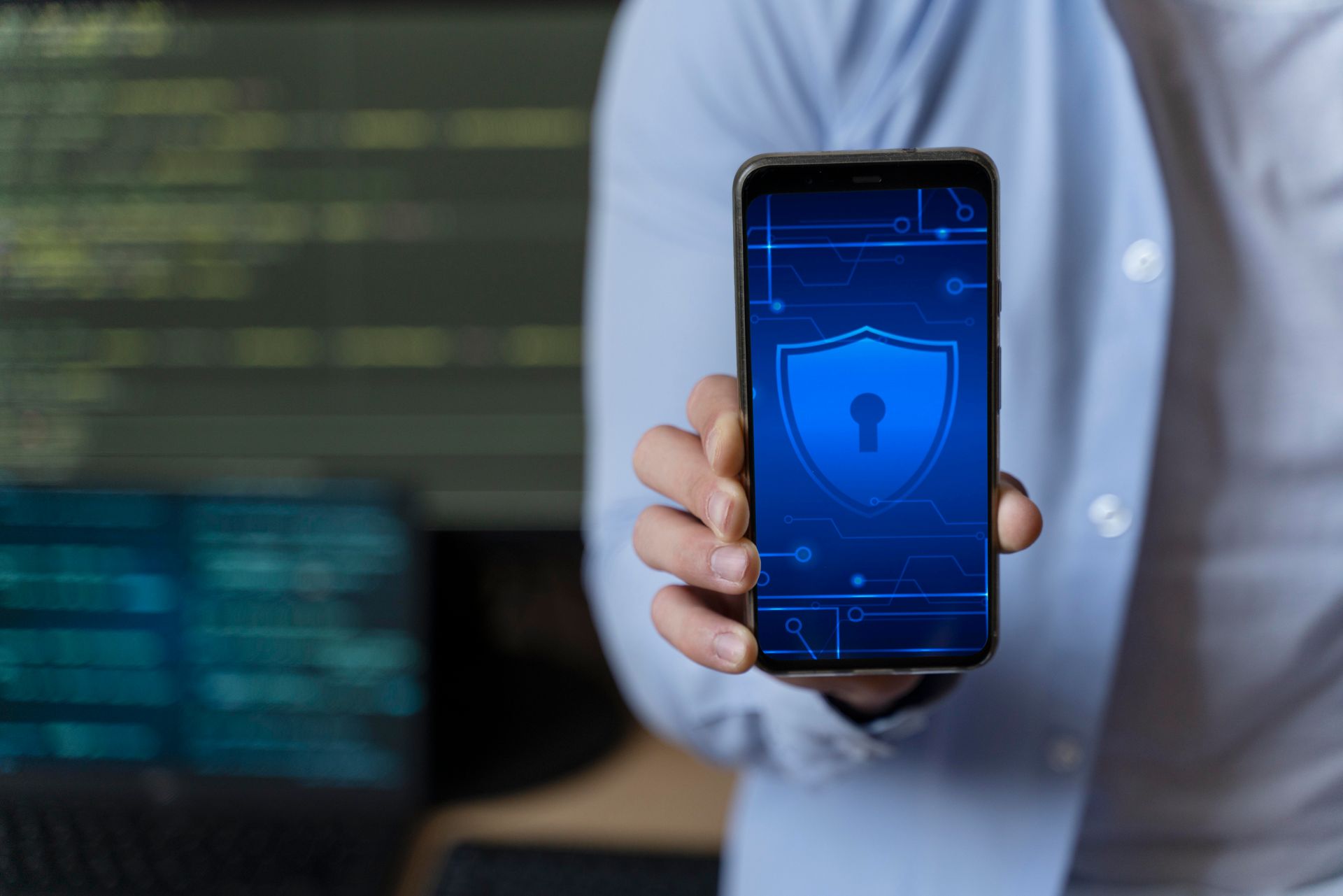 Uma pessoa segurando um smartphone com um ícone de escudo de segurança azul