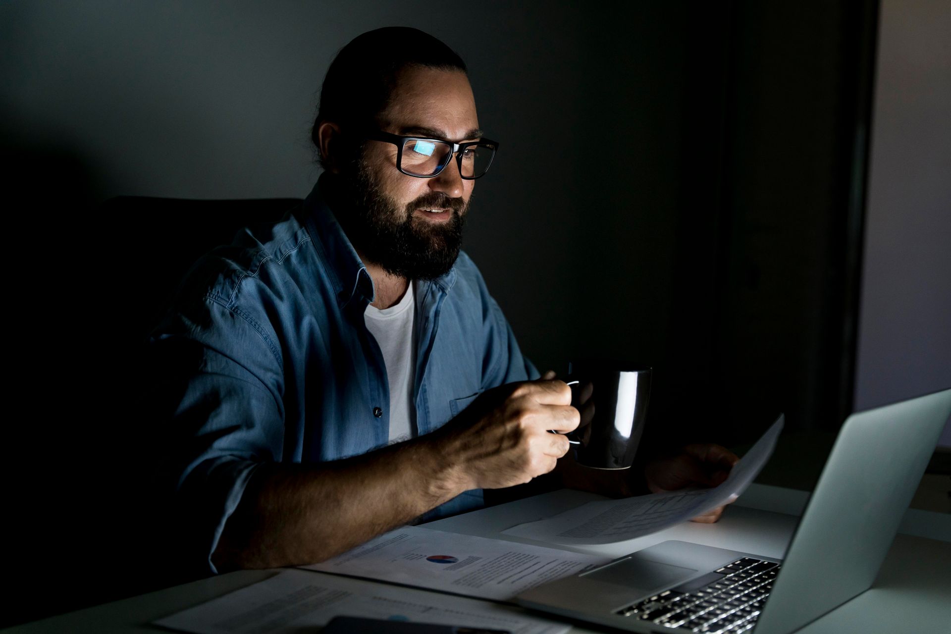 homem sentado à mesa, trabalhando à noite.