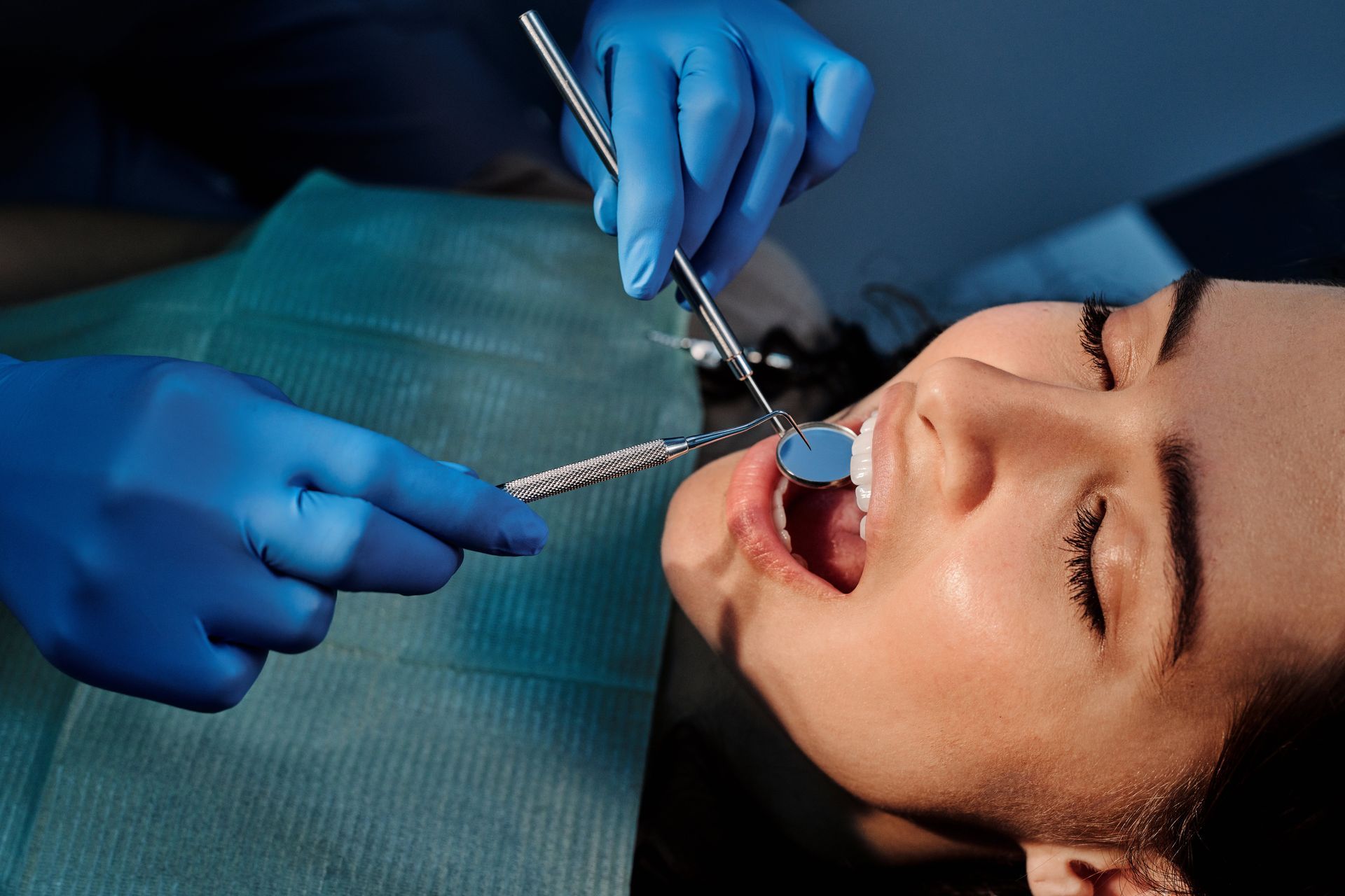 A woman is having her teeth examined by a dentist.