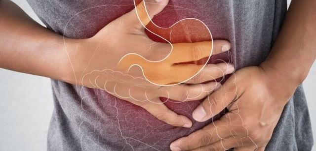 A person is holding their stomach in pain.
