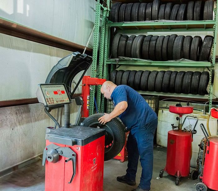Mechanic balances a tire in a garage | Turnage Auto Care Center
