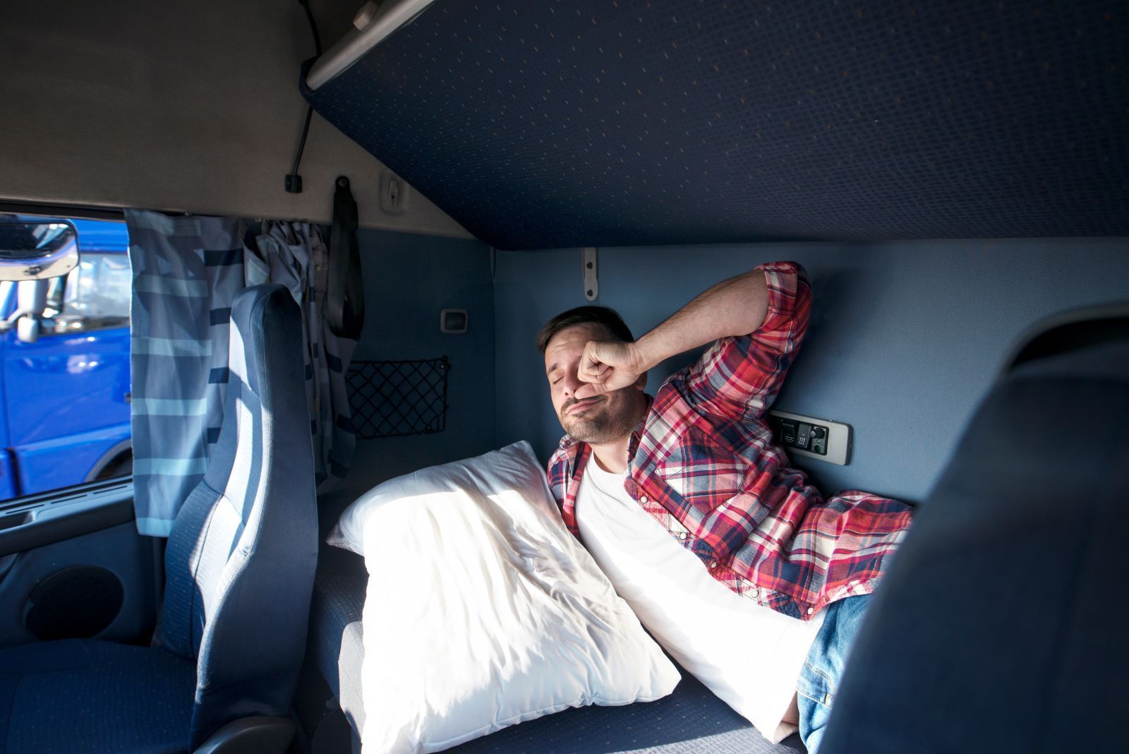 a man is sleeping in the back of a truck .