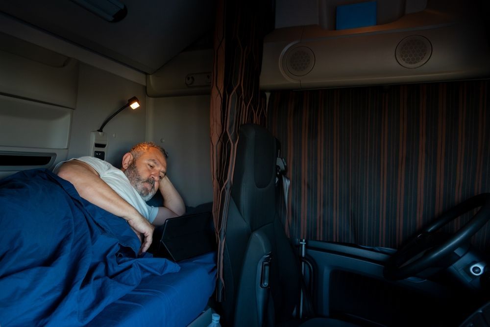 a man is sleeping in a truck bed .