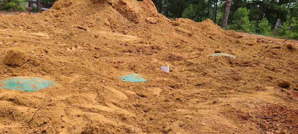 A pile of dirt is sitting on top of a dirt field.