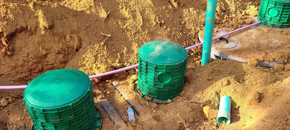 A group of green containers sitting on top of a pile of dirt.