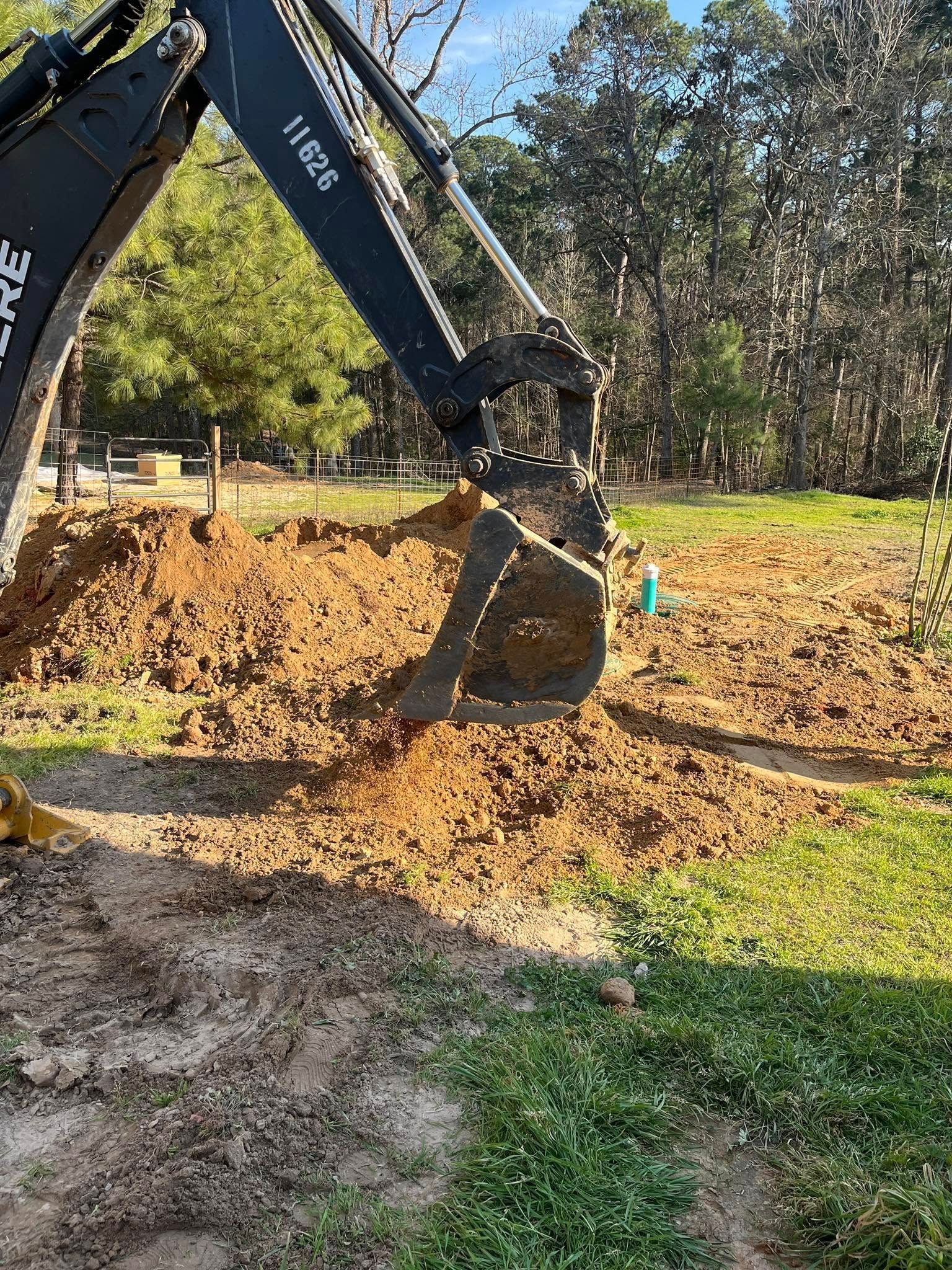 A bulldozer is digging a hole in the dirt in a field.