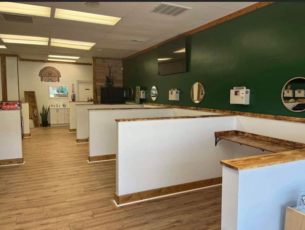 Empty office lobby with wood floors, white counters, and a dark green wall
