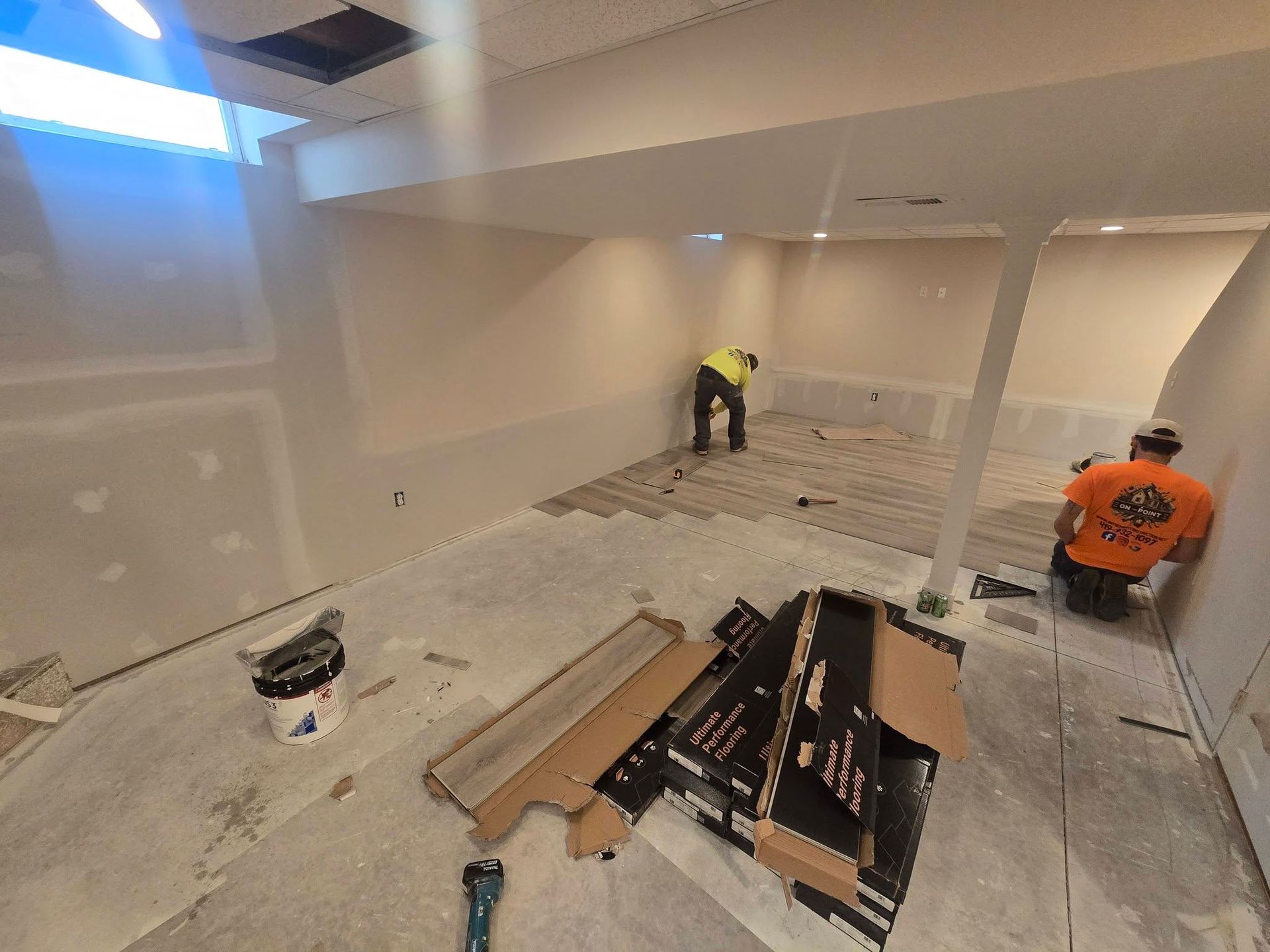 Finished basement with carpet, staircase, and a small built-in desk nook.