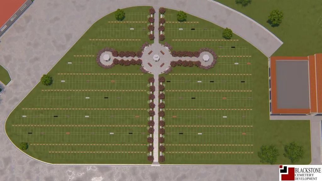 Aerial view of a landscaped cemetery. Green grass plots with pathways, a central monument, and trees.