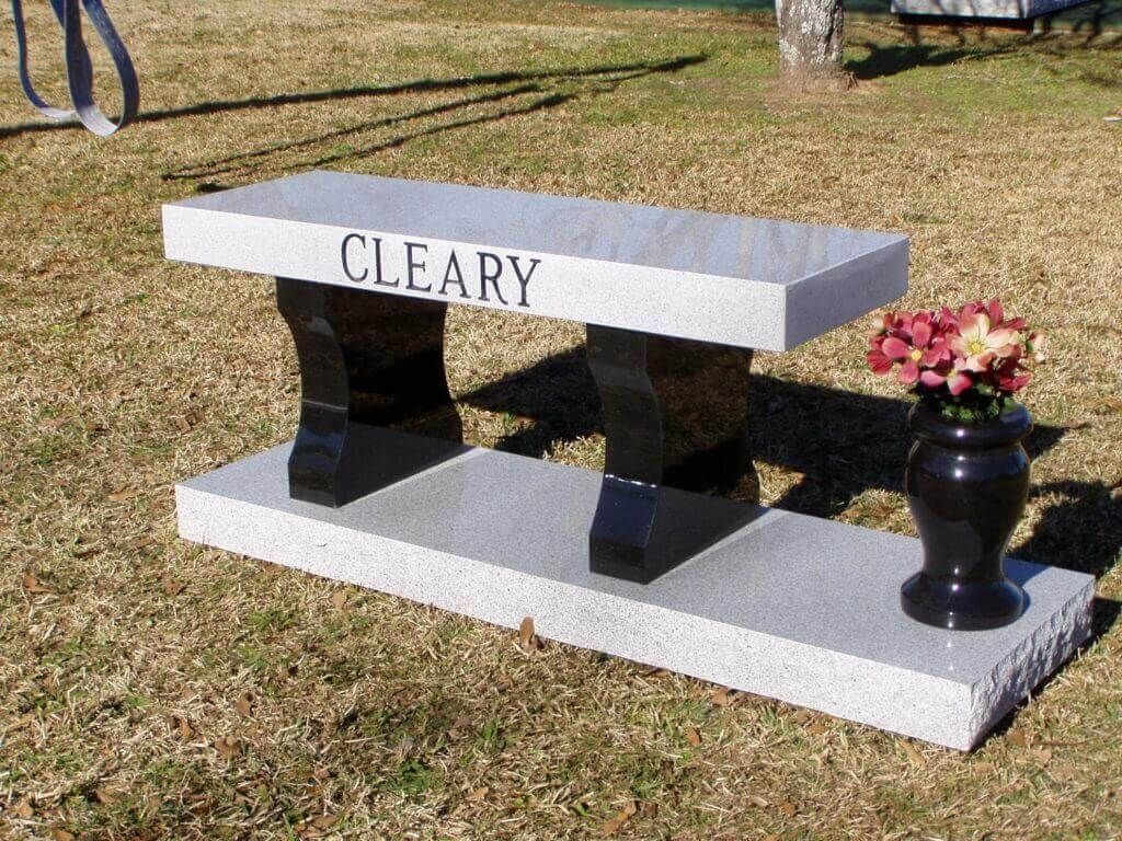 Granite bench in a grassy area, inscribed with