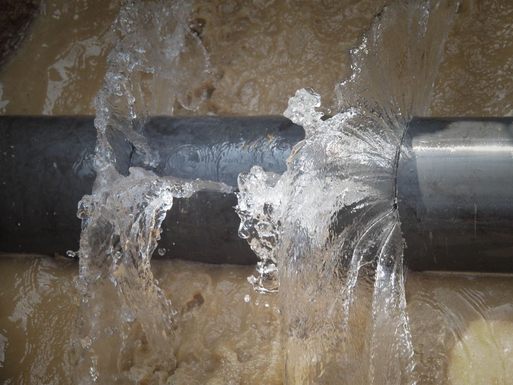 Water Gushing from A Broken Pipe, Flooding a Brown Surface — Harwood Plumbing & Gasfitting Pty Ltd in Alawa, NT