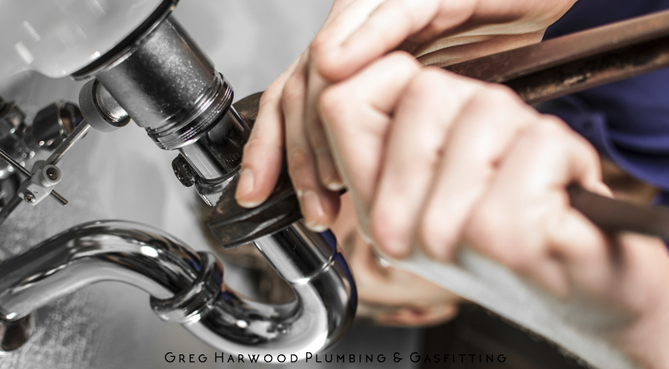Hands Tightening a Pipe Fitting With a Wrench Under a Sink, Plumbing Repair — Harwood Plumbing & Gasfitting Pty Ltd in Alawa, NT