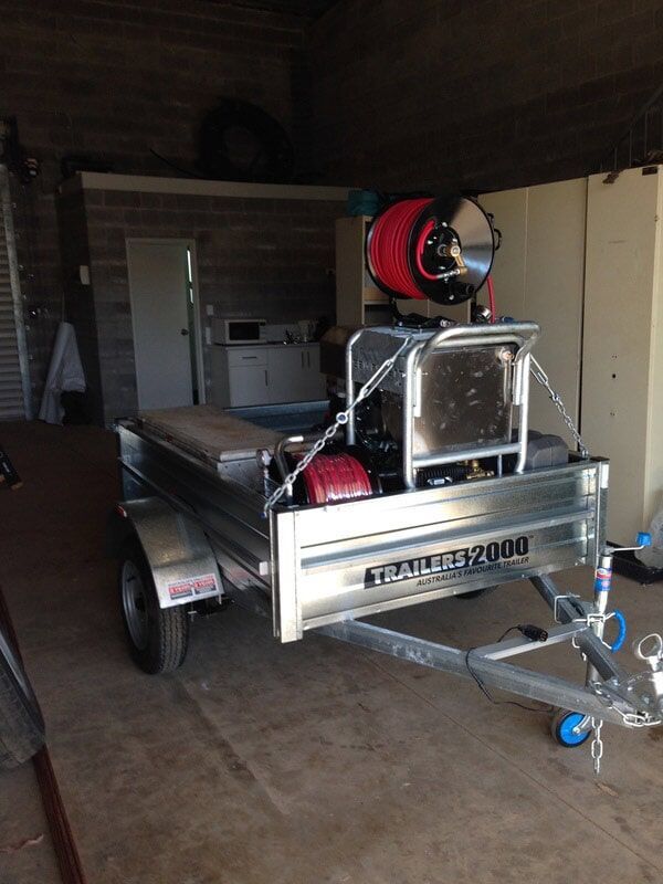 A Metal Trailer With Equipment for Pressure Washing Inside a Garage — Harwood Plumbing & Gasfitting Pty Ltd in Alawa, NT