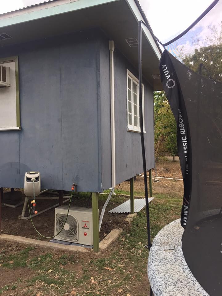 A Trampoline is Sitting in Front of a Blue House — Legit Air Conditioning & Refrigeration in Garbutt, QLD