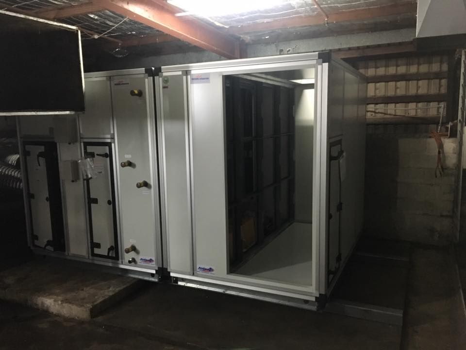 A Large White Box is Sitting in a Dark Room — Legit Air Conditioning & Refrigeration in Garbutt, QLD