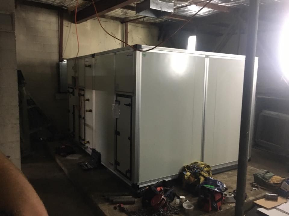 A Large White Box is Sitting in a Dark Room — Legit Air Conditioning & Refrigeration in Garbutt, QLD