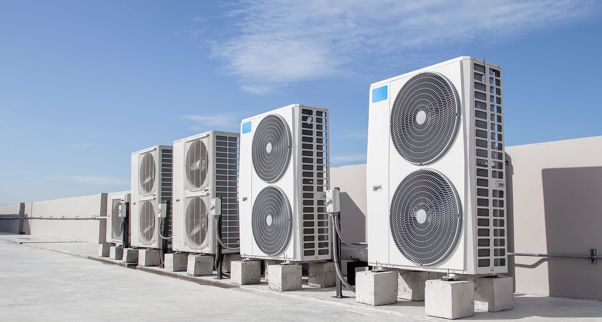 A Row of Air Conditioners Are Sitting on Top of a Building — Legit Air Conditioning & Refrigeration in Garbutt, QLD