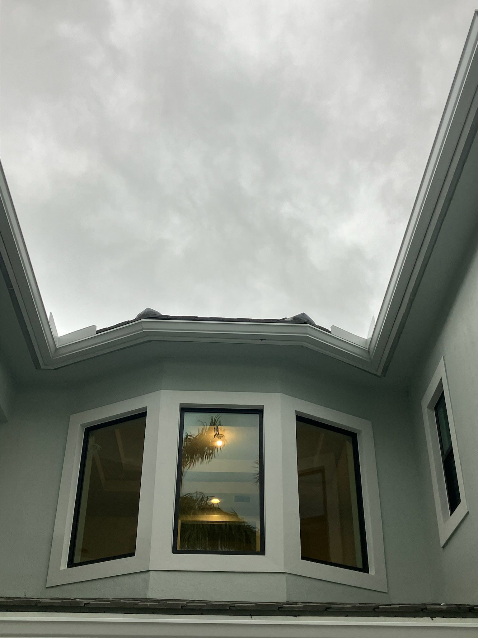 Black metal roof with matching gutters and downspouts, angled shot.