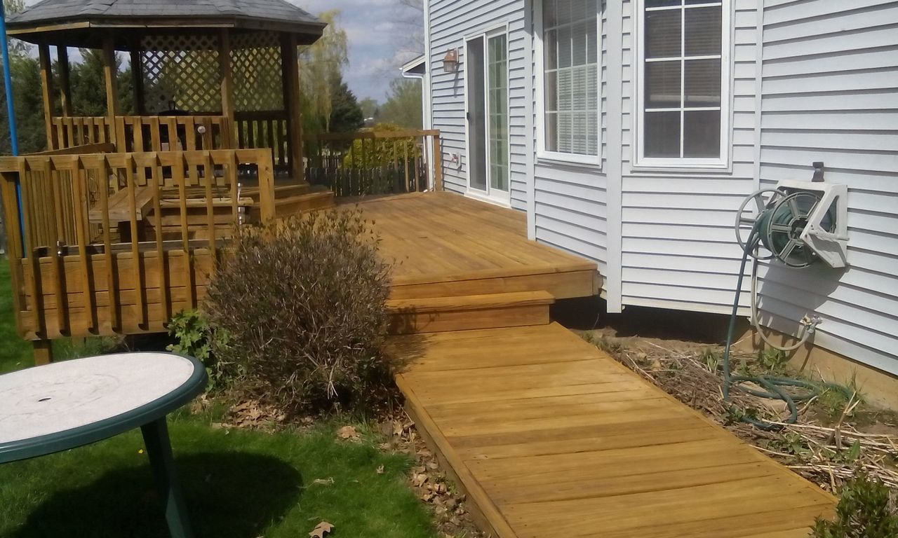 A white house with a wooden deck and gazebo