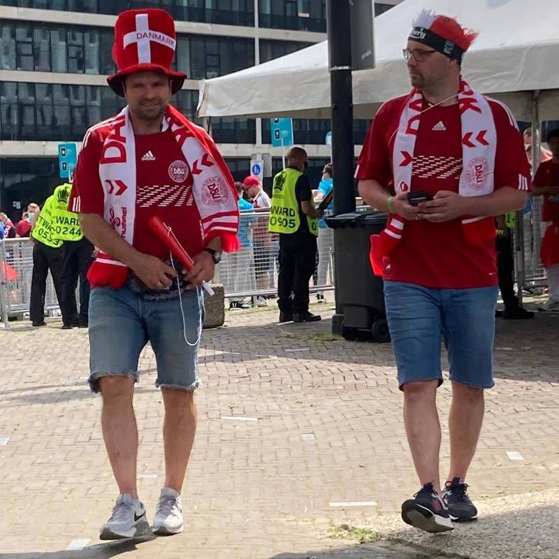Een man die een rood shirt draagt ​​met daarop da