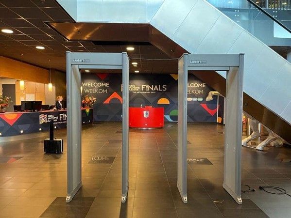Drie metaaldetectoren in een lobby met trappen op de achtergrond