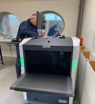Een man werkt op een computer voor een röntgenapparaat.
