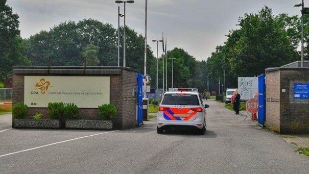 Een politieauto staat geparkeerd voor een gebouw