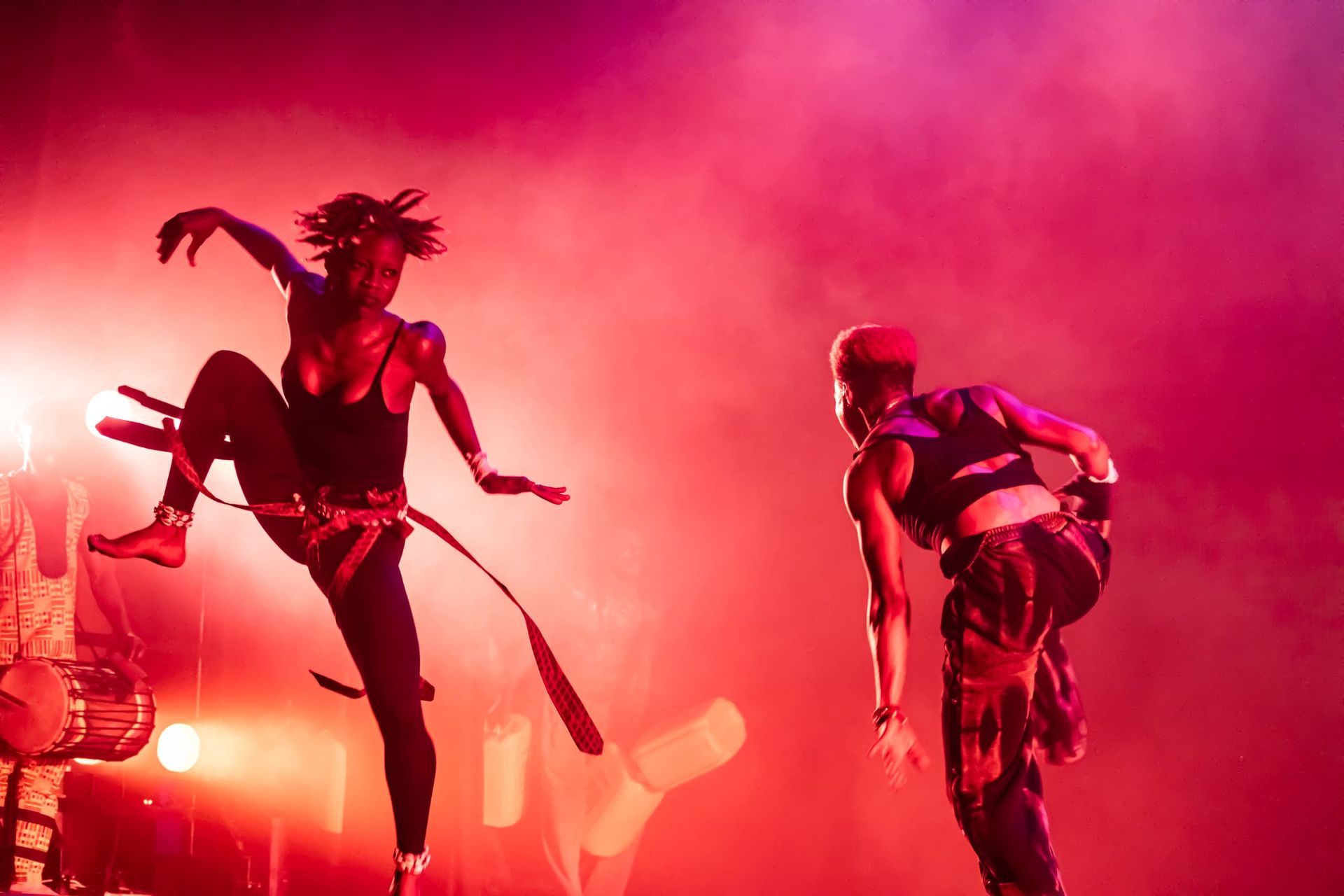 One person dancing with their leg in the air. Dramatic red lighting