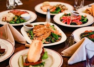A table topped with plates of food and napkins.
