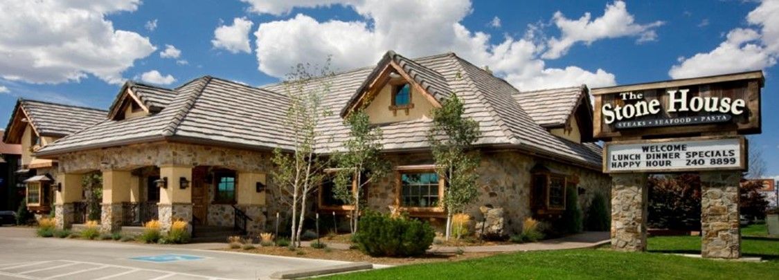 A large stone house with a sign in front of it. A large stone house with a sign in front of it.
