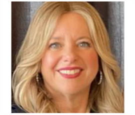A woman with blonde hair and red lipstick is smiling for the camera. Beverley Honig