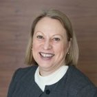A woman in a gray jacket and white shirt is smiling for the camera. Dr Michelle Sheilds