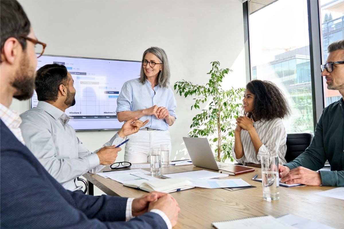 A group of people are sitting around a table having a meeting.