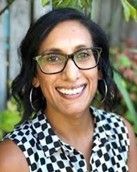 A woman wearing glasses and a polka dot shirt is smiling for the camera. Samantha Patel