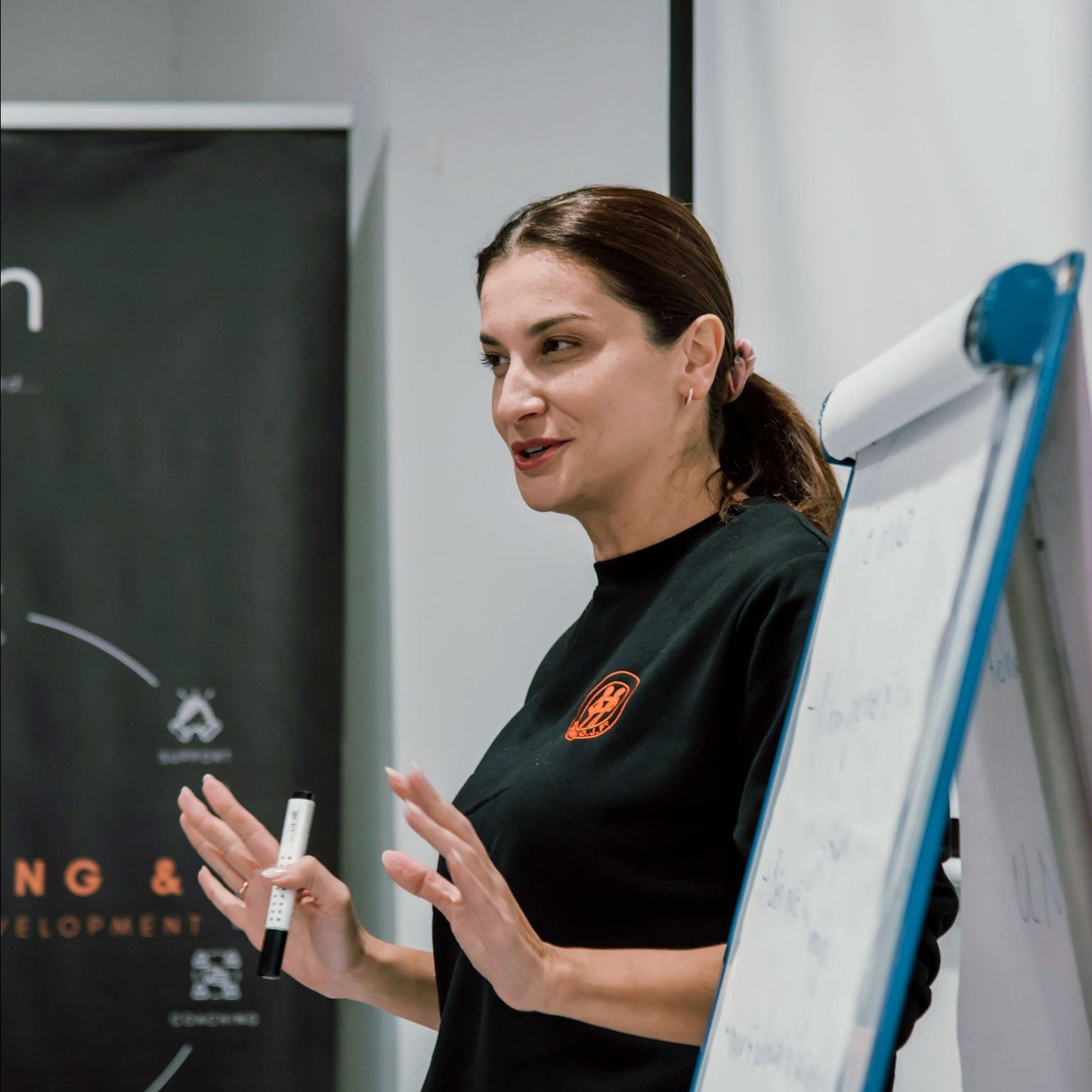 A woman stands in front of a white board with the word development on it