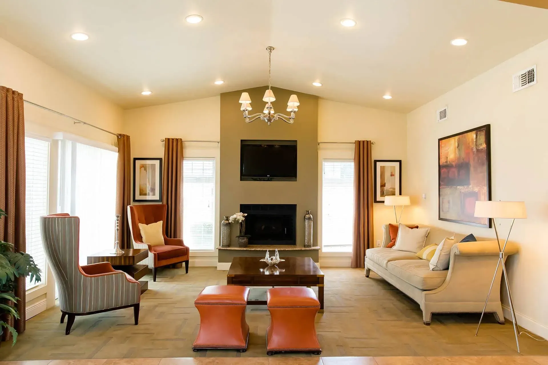 Spacious living room with fireplace, TV, comfortable seating, and large windows.